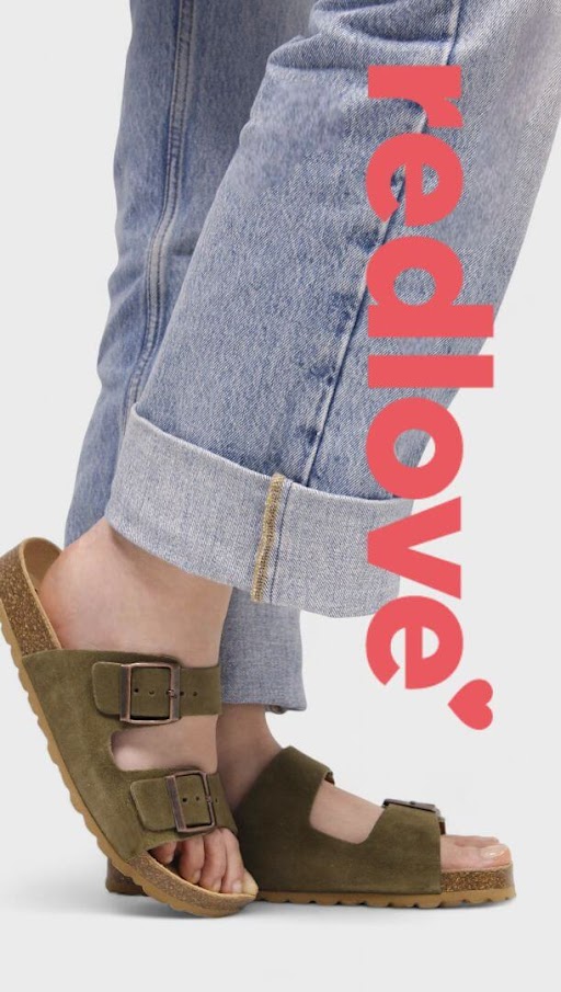 Persona usando sandalias tipo bio color verde oliva con suela de corcho y hebillas metálicas, combinadas con pantalones de mezclilla doblados a la altura del tobillo. Al lado derecho aparece el texto grande en vertical redlove con un corazón rojo.